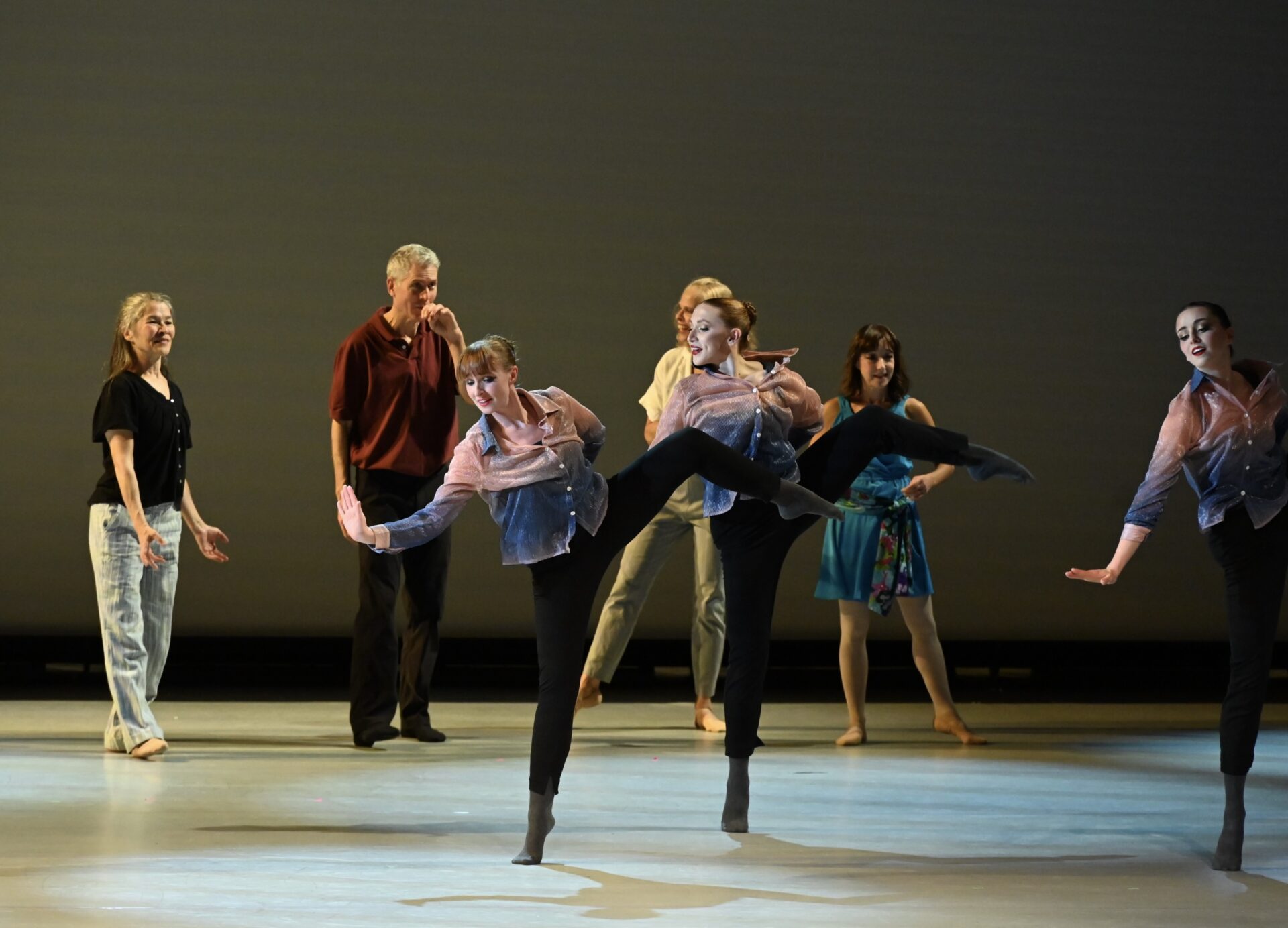 dancers on stage performing with a grey background