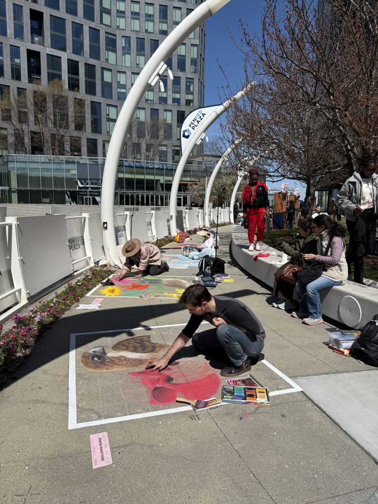 Artists creating art on a paved concrete plaza for a chalk art contest.