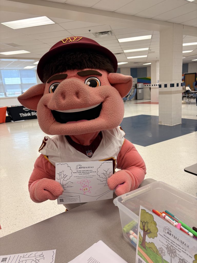 Washington Commanders "Major Tuddy" holds up his ArtsFairfax coloring sheet artwork