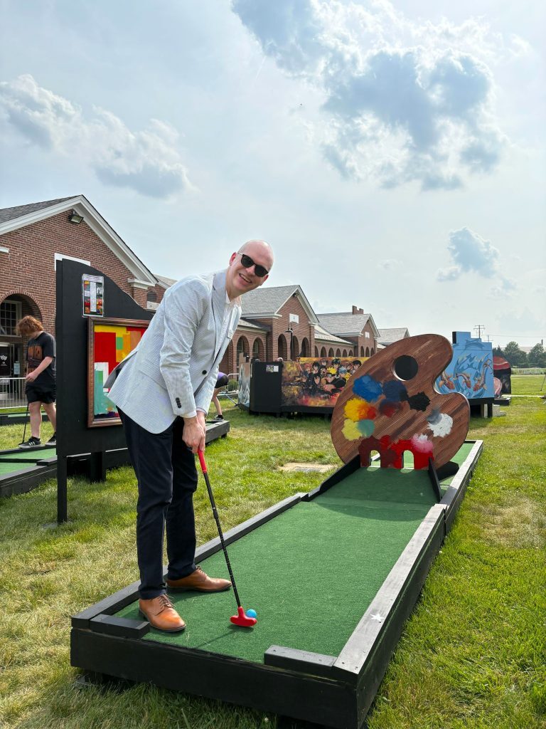 ArtsFairfax President & CEO Stuart Holt enjoying a game of mini golf at Workhouse Arts Center’s Masterpiece Mini Golf.