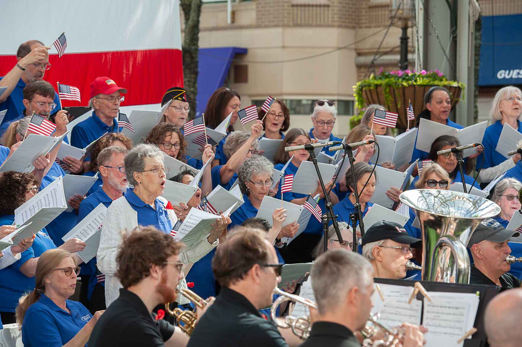an orchestra plays instruments with small american flags on their music stands